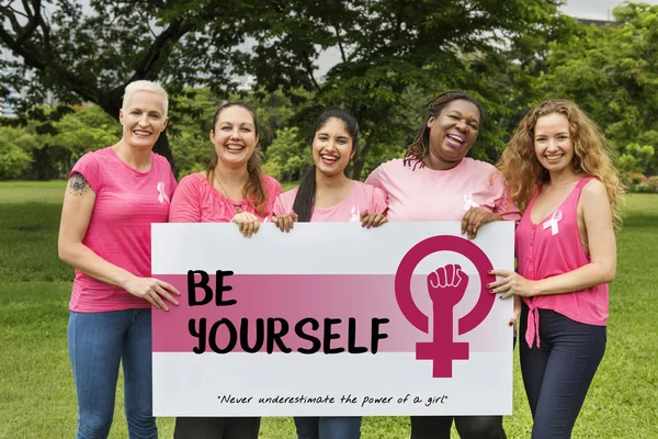 Mujeres en camisas rosas sosteniendo pancarta — Foto de Stock