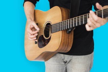 Adam akustik gitar çalıyor.