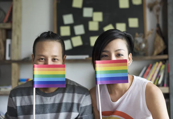 Pareja lesbiana sosteniendo banderas — Foto de Stock