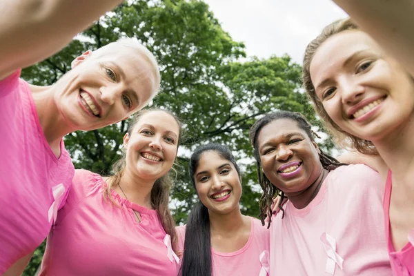 Donne in camicie rosa in piedi insieme — Foto Stock