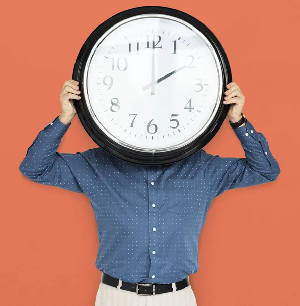 Hombre celebración reloj cubriendo la cara — Foto de Stock