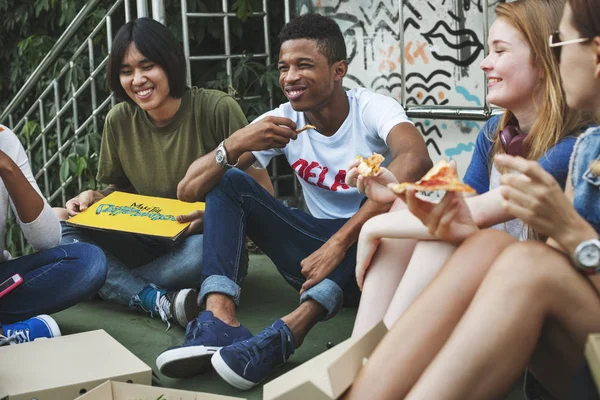 Amici seduti sul pavimento e mangiare pizza — Foto Stock