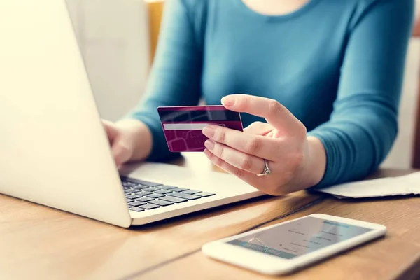 Femme utilisant un ordinateur portable et carte de crédit — Photo