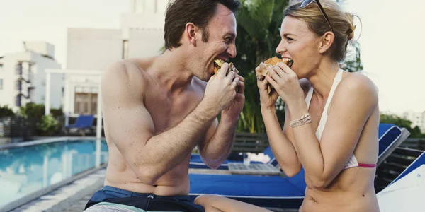 Coppia mangiare vicino alla piscina — Foto Stock