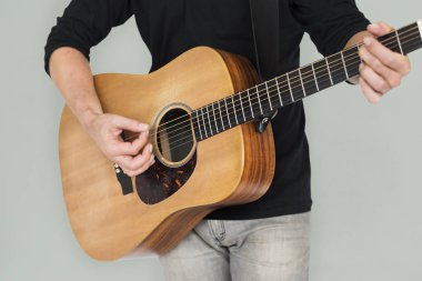 Adam akustik gitar çalıyor.