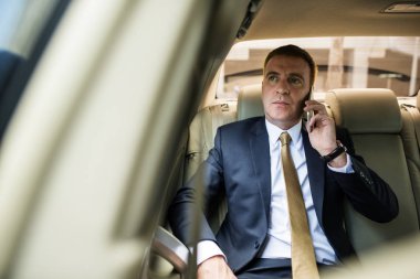 smartphone üzerinde konuşan işadamı