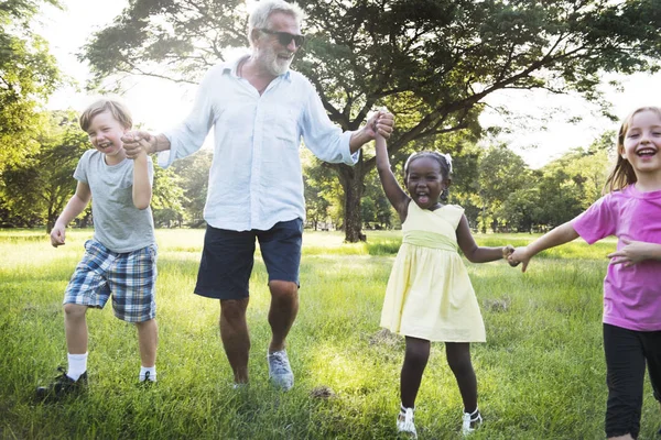 Grandfather with kids in summer park — Stock Photo, Image