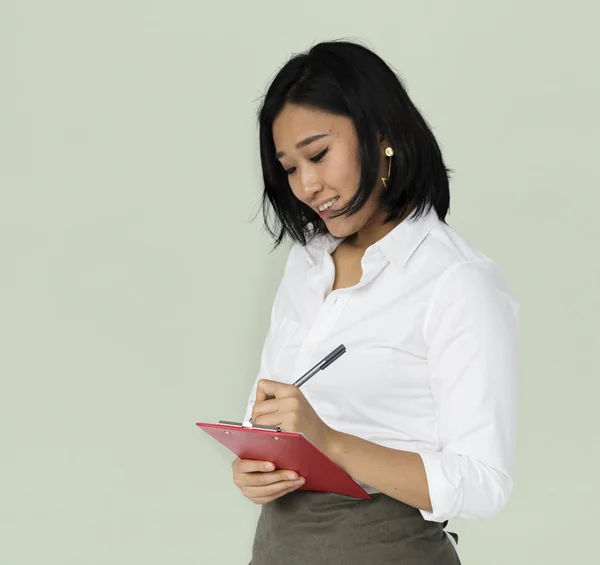 Азиатская бизнесвумен, пишущая в блокнот — стоковое фото