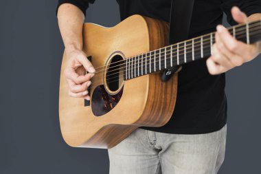 Adam akustik gitar çalıyor.