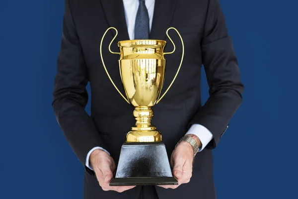 Empresário segurando troféu — Fotografia de Stock
