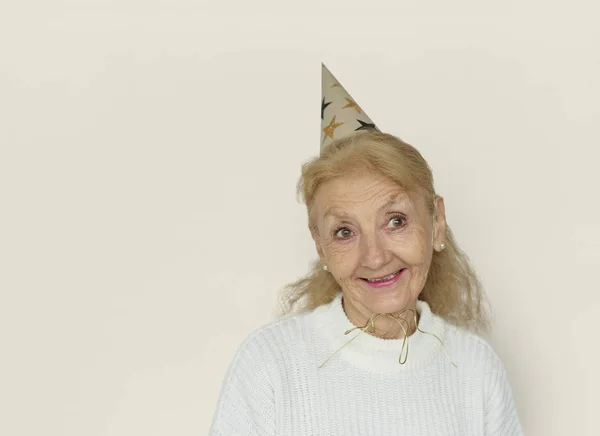 Mulher Sênior usando chapéu de festa — Fotografia de Stock