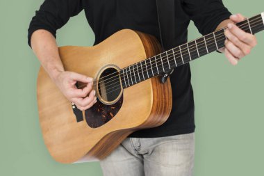 Adam akustik gitar çalıyor.