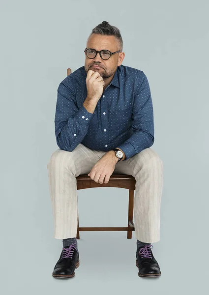 Hombre sentado en silla de madera —  Fotos de Stock