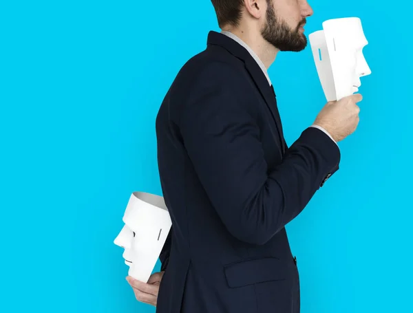 Businessman holding masks — Stock Photo, Image