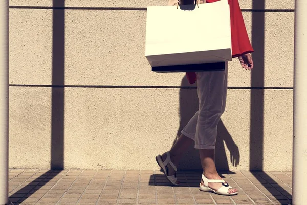 Kvinnan promenader med shopping väska — Stockfoto