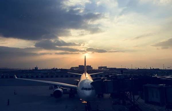 Vliegtuig op luchthaven met zonsondergang — Stockfoto