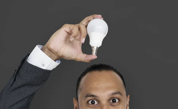 Uomo d'affari in possesso di lampadina — Foto Stock