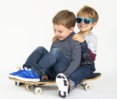 Kaykay üzerinde oturan çocuklar