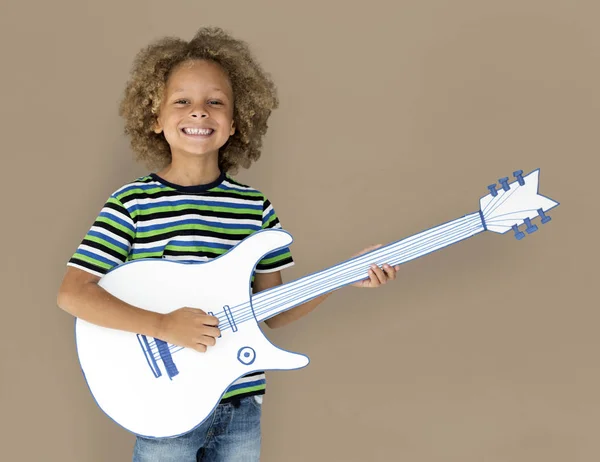 Мальчик играет на бумажной гитаре — стоковое фото