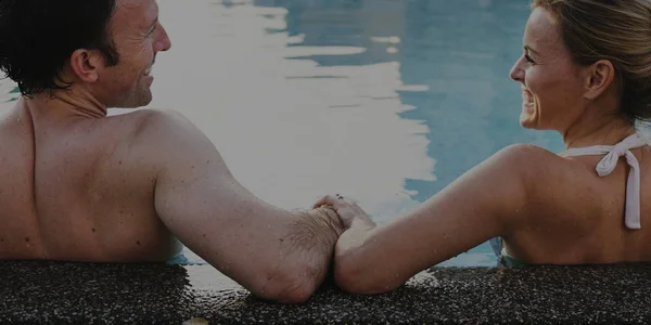 Пара сидить біля басейну — стокове фото