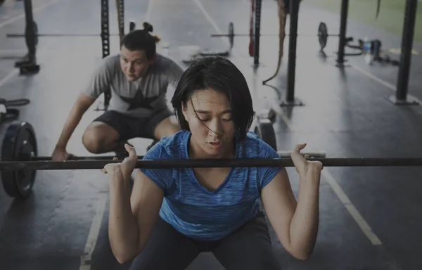 Menschen trainieren mit Trainingsgeräten — Stockfoto