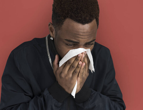 sick African man sneezing