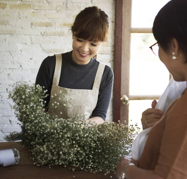 Blumenhändlerin verkauft Blumenstrauß an Kunden — Stockfoto