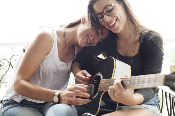 Lesbian Couple playing guitar