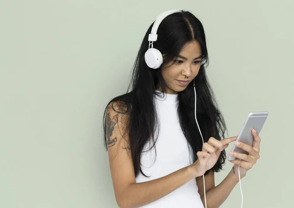 Nő használ mozgatható telefon és a fejhallgató — Stock Fotó