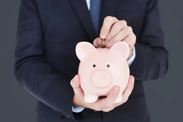 Uomo d'affari mettere soldi in Piggy Bank — Foto Stock