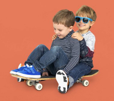 Kaykay üzerinde oturan çocuklar