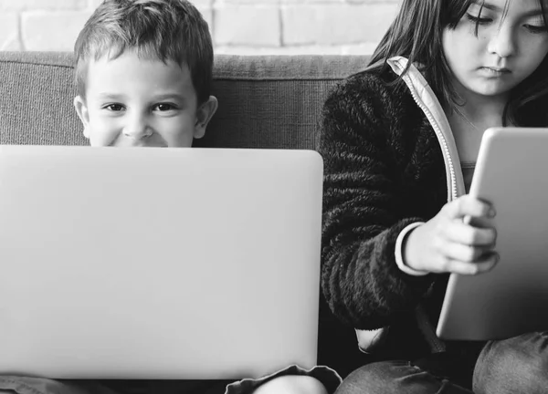 Schwester und Bruder mit digitalen Geräten — Stockfoto