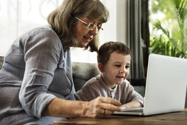 Mormor med laptop med barnbarn — Stockfoto