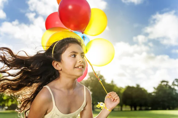 Flicka kör med ballonger — Stockfoto