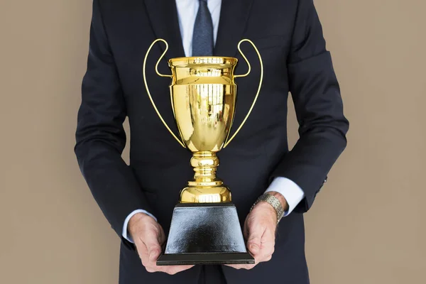 Homem de negócios segurando troféu — Fotografia de Stock