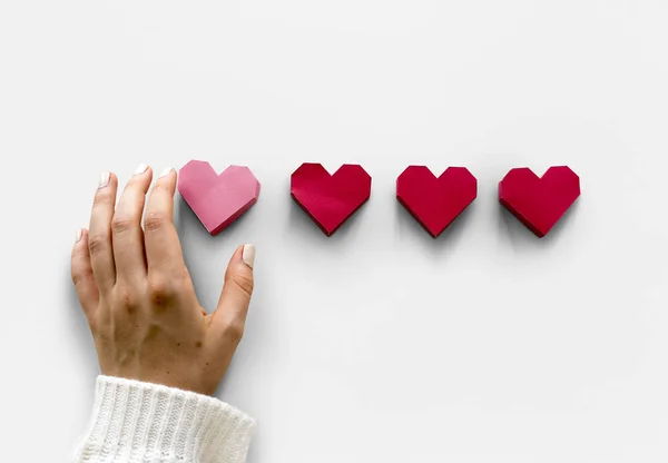 Mão segurando corações de papel — Fotografia de Stock