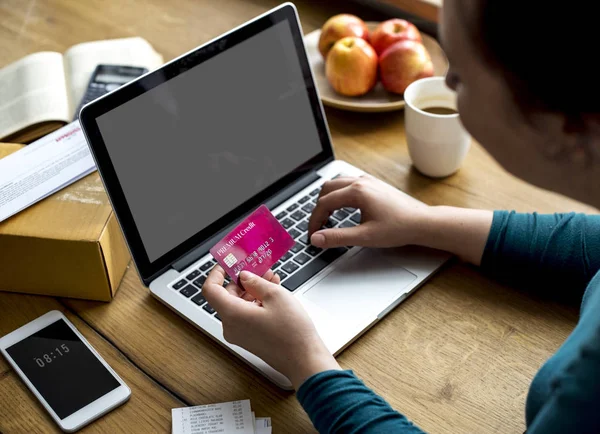 Femme utilisant un ordinateur portable et carte de crédit — Photo