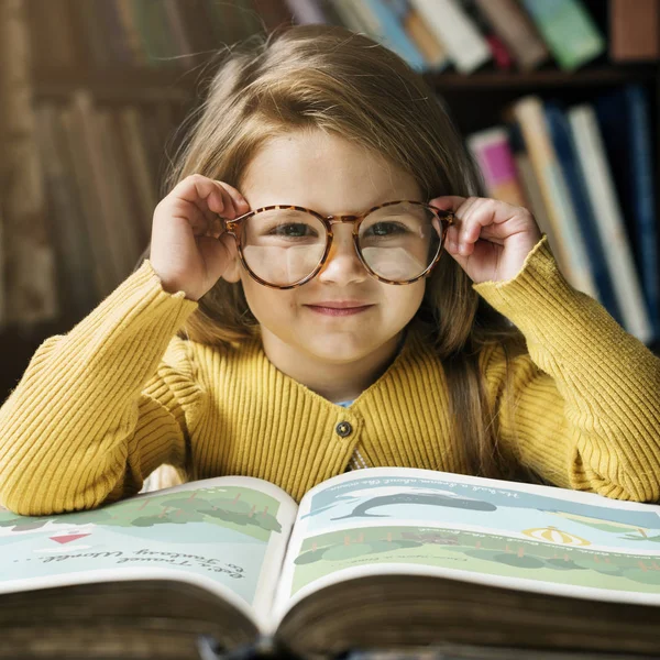 Flicka med glasögon och bok. — Stockfoto