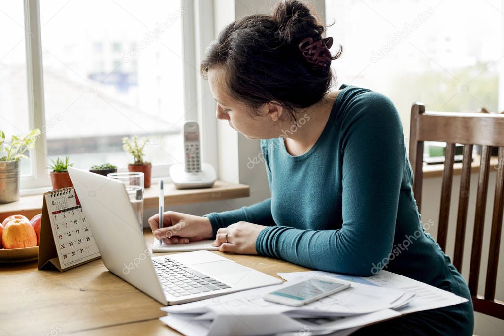 woman using laptop and writing
