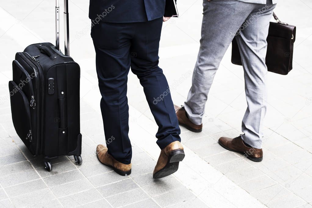 Businessmen walking with luggage