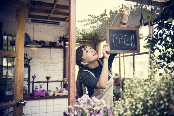 saleswoman holding open sign board