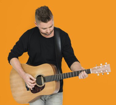 Adam akustik gitar çalıyor.