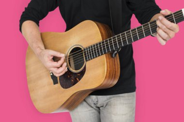 Adam akustik gitar çalıyor.