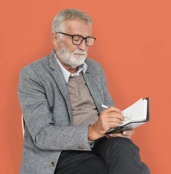 Homme d'affaires senior Écrire dans un carnet — Photo