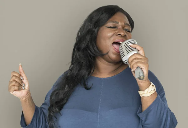 African woman singing in microphone — Stock Photo, Image