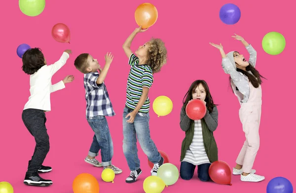 Kindergruppe spielt mit bunten Luftballons — Stockfoto