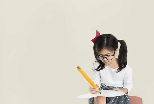 Mädchen schreibt mit großem Bleistift — Stockfoto