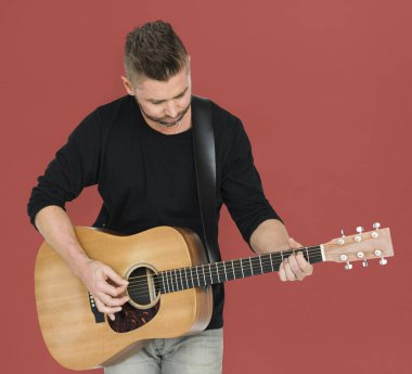 Adam akustik gitar çalıyor.