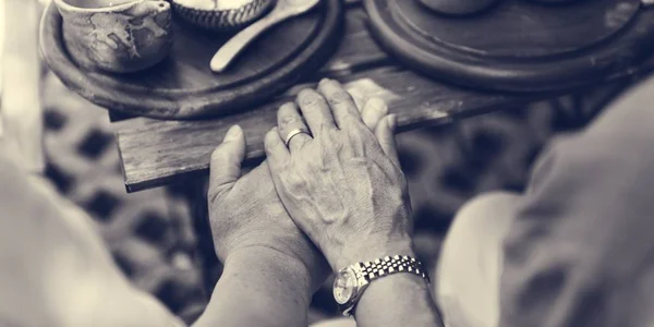 Aged couple holding hands — Stock Photo, Image