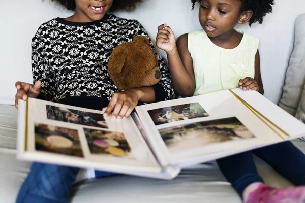 Lilla systrar titta på fotoalbum — Stockfoto